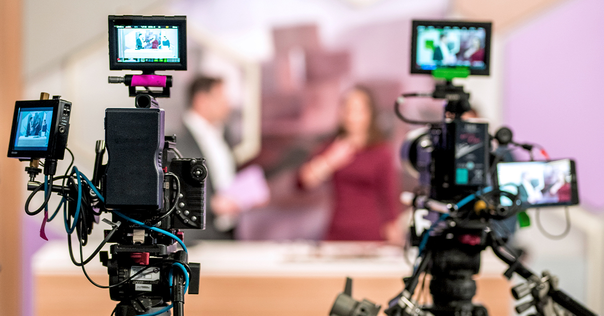 two people being filmed by cameras during interviews