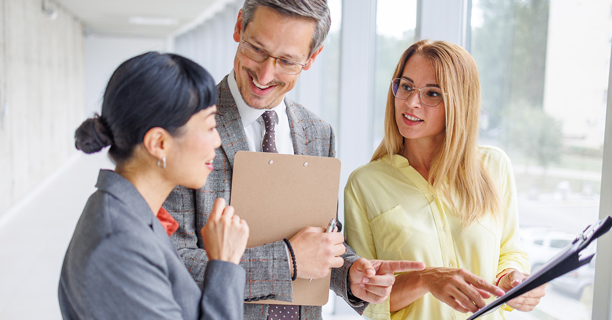 three business professionals consulting in hallway