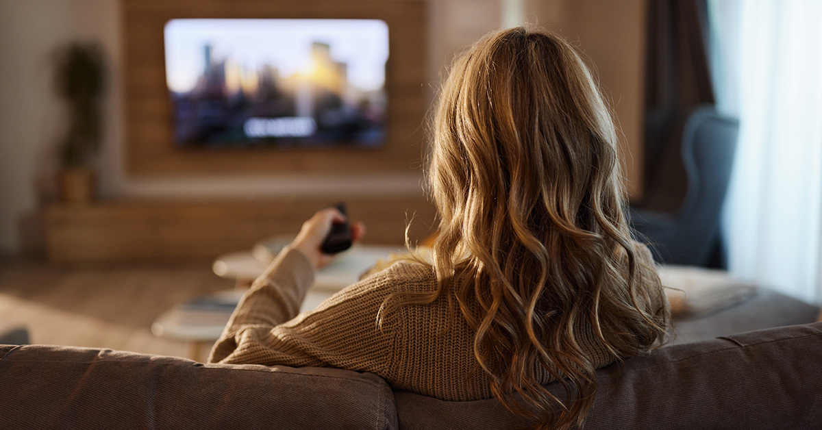 woman sitting on couch watching TV