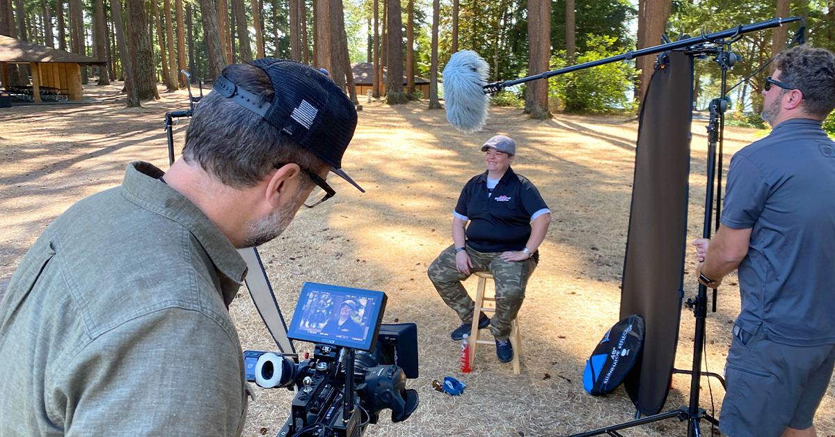 person smiling while being filmed by video crew